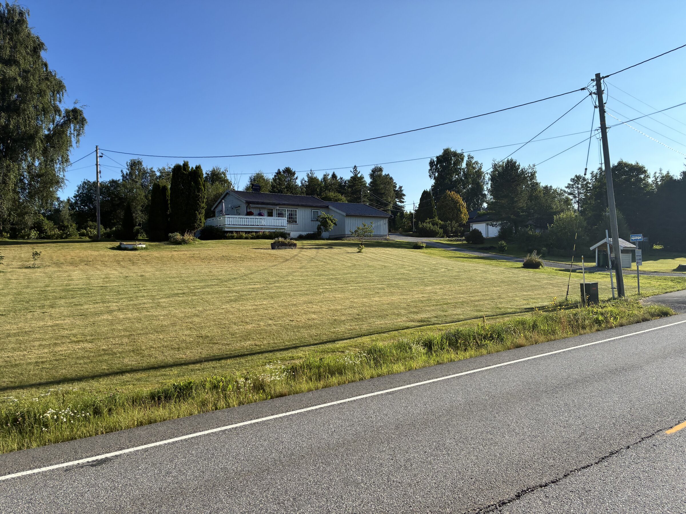 Schwedische Morgenlandschaft mit Straße, Feldern und Häusern