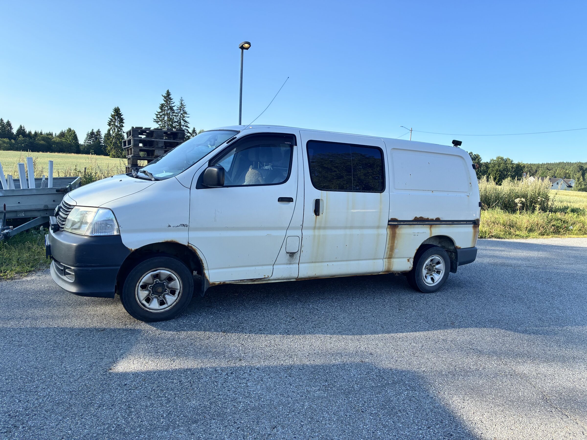 Weißer Wagen an der Straße in der schwedischen Landschaft